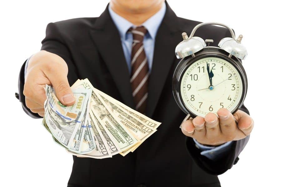 businessman holding money and clock. time is money concept ** Note: Shallow depth of field