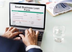 Professional filling out business loan form online