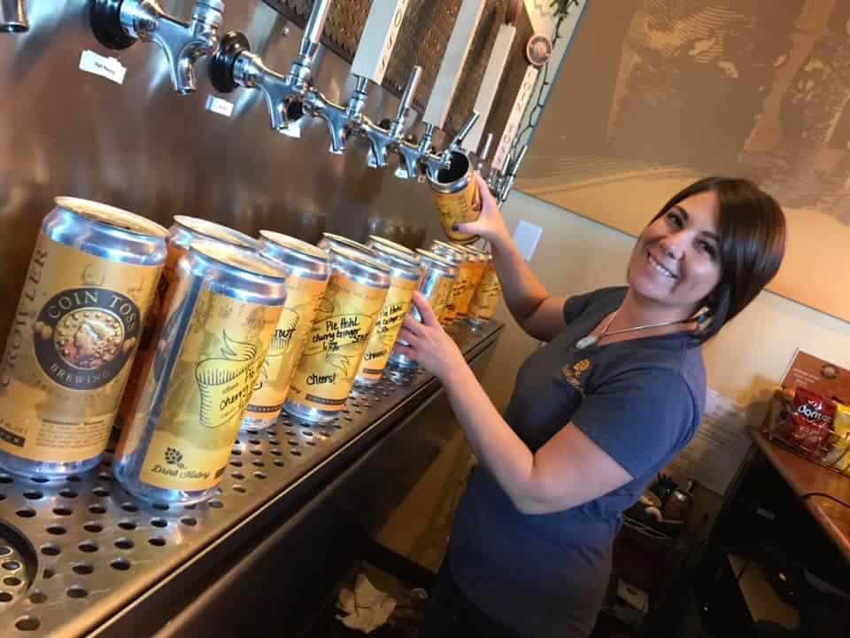 A server fills aluminum containers with beer for pickup and delivery