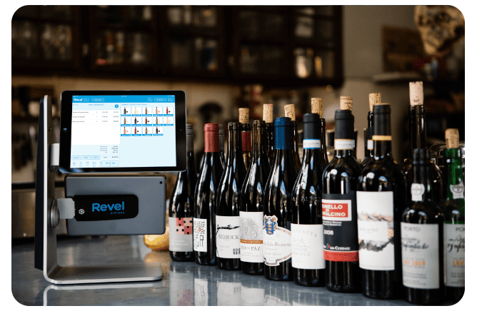 Photo of Revel Winery POS system on an iPad next to bottles of wine