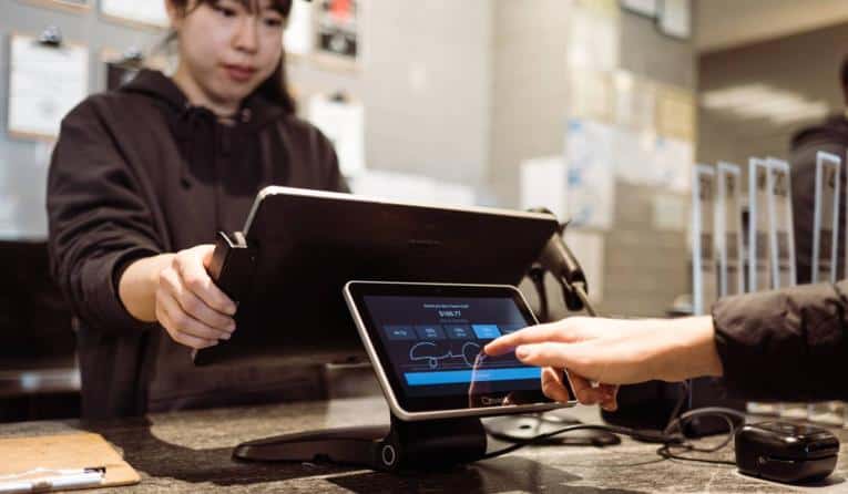 Customer signing on customer-display screen attached to Toast countertop POS register