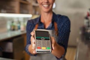 Waitress holds POS device in Australia
