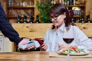 woman using pos at a Canadian restaurant