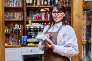 Woman worker manager of restaurant holding wireless payment terminal