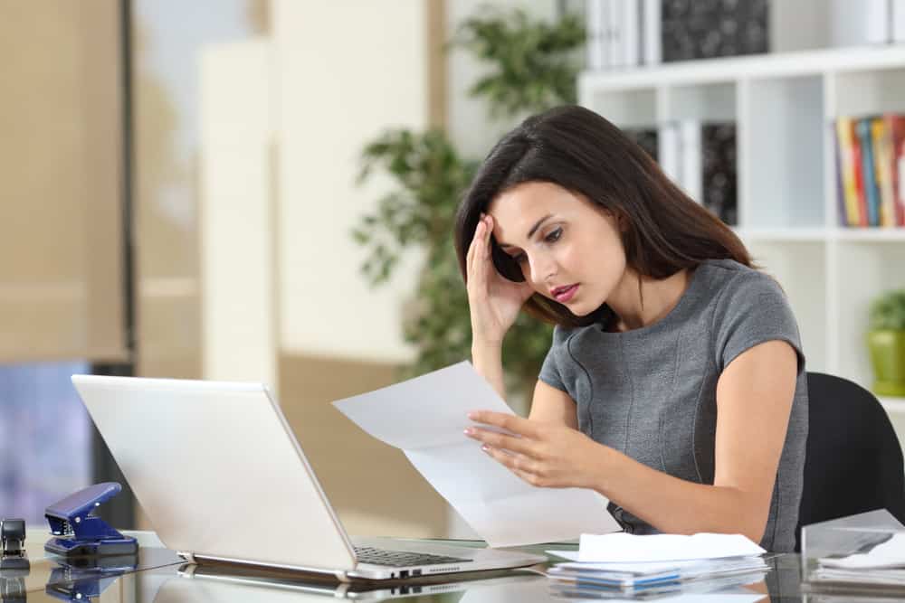 Woman reading a letter from the IRS about her ERC tax claim.